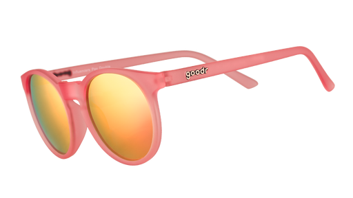 Vista en ángulo de tres cuartos de unas gafas de sol redondas de color rosa con cristales polarizados espejados de color rosa.
