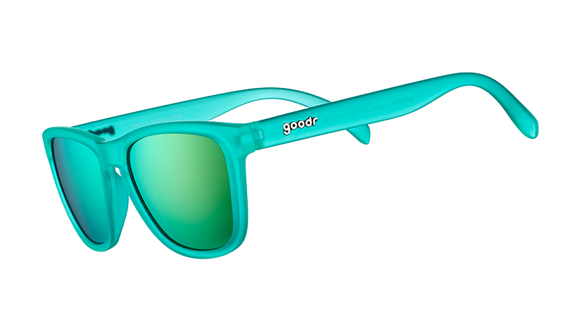 Vista en ángulo de tres cuartos de unas gafas de sol cuadradas de color verde azulado con lentes polarizadas reflectantes de color verde azulado.